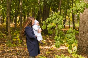 Beautiful lifestyle autumn photo mother and child walks in the park, warm sunlight